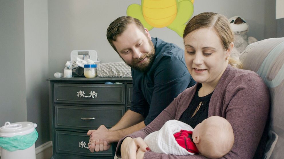 n this undated photograph provided by Penn Medicine, Jennifer and Drew Gobrecht look at their baby, Benjamin, at home in Ridley Park, Pa. Jennifer gave birth in November 2019 following a uterine transplant. (Penn Medicine via AP)